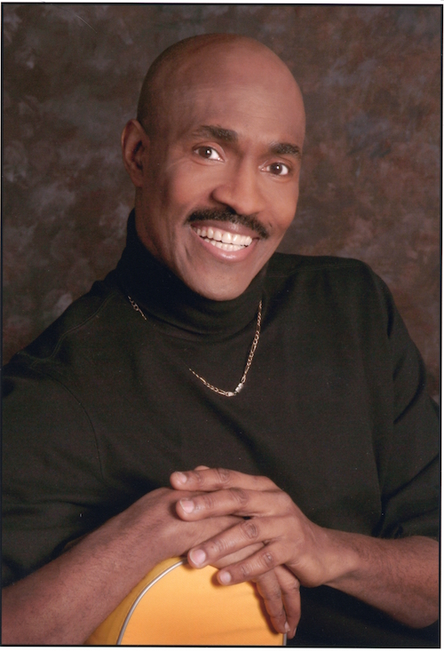 A headshot of Mr. Bryant. He wears a black turtleneck and is smiling